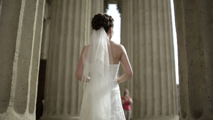 Lovely bride goes among the columns