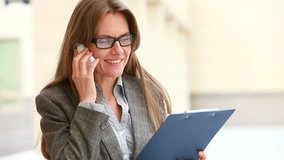 Ambitious business lady discussing business by phone outdoors