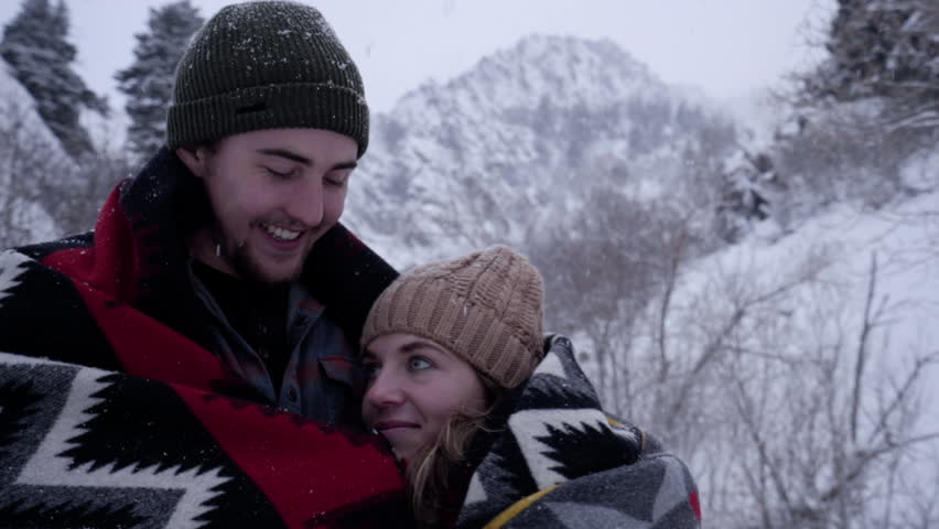 Closeup Portrait Of Happy Couple Enjoying A Snowy Winter Day In The Utah Mountains, Man Kisses Girlfriend On Head