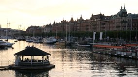 City canal in Stockholm, Sweden at dusk. Jetty, boat marina and cityscape buildings