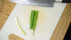 The green part of spring onions being cut into rings