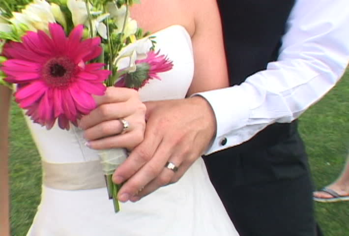 Bride and Groom after wedding show off wedding rings to camera. More available