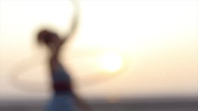 Active joyful woman at the beach playing with hula hoop at sunrise in fashion dress. Blur. Copyspace text. - Powered by Shutterstock - Get 15% off with code: PIKWIZARD15