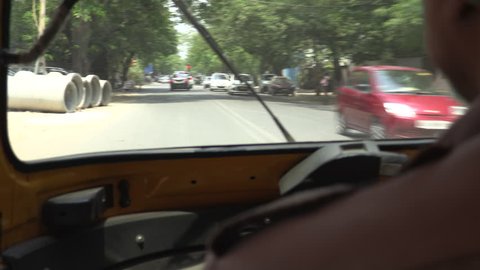 Busy streets of New Delhi, India as seen through an auto rickshaw.