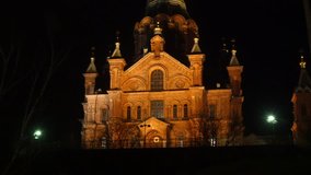 Zooming timelapse of people walking infront of Uspenski Cathedral, at a dark evening night, in Helsinki, Finland.