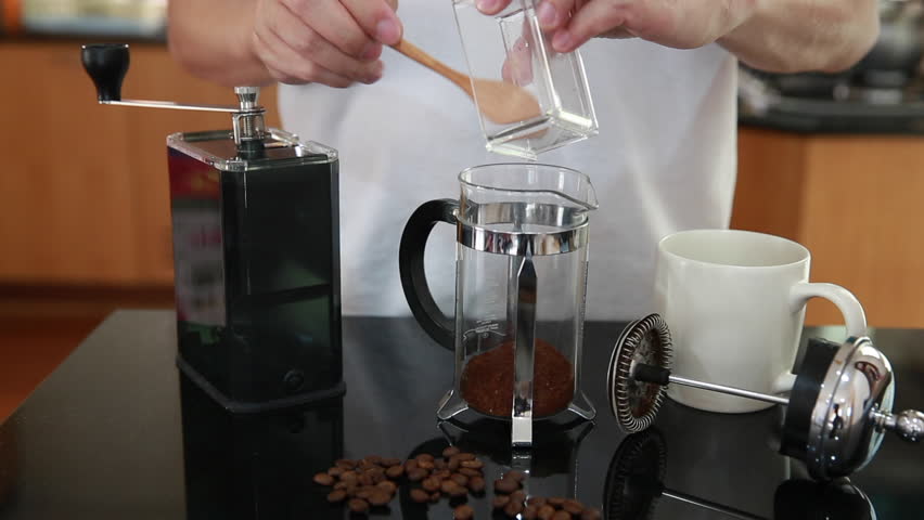 Man in casual dress preparing coffee in kitchen