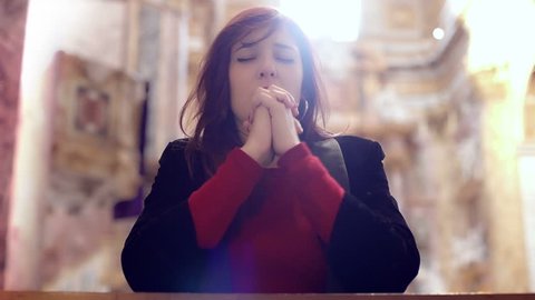 female praying alone in church
