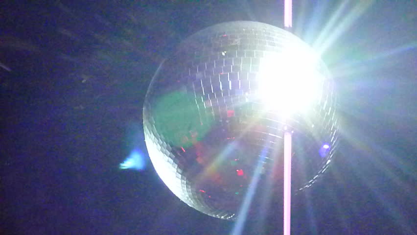 Nightclub disc ball spinning, reflecting light to zoom out - tilt down to people