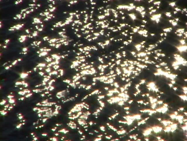 Water reflects golden stars from the sun on Minnesota Lake.