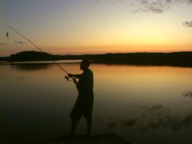 Man casts fishing pole into calm lake water in Minnesota.
