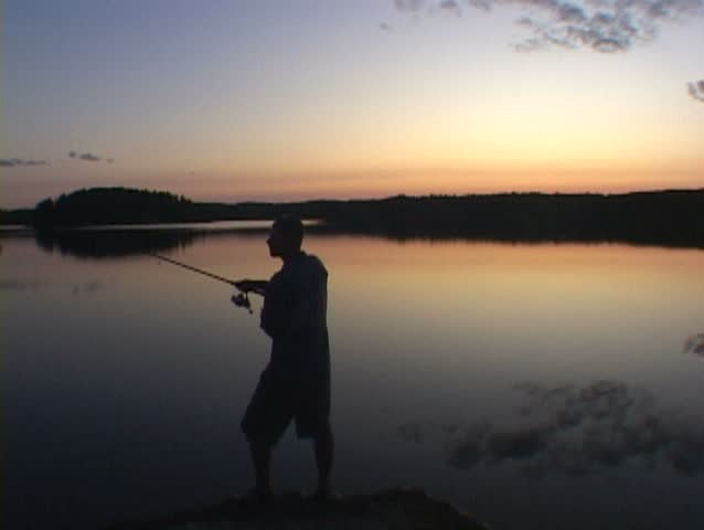 Man casts fishing pole into lake water in Minnesota.