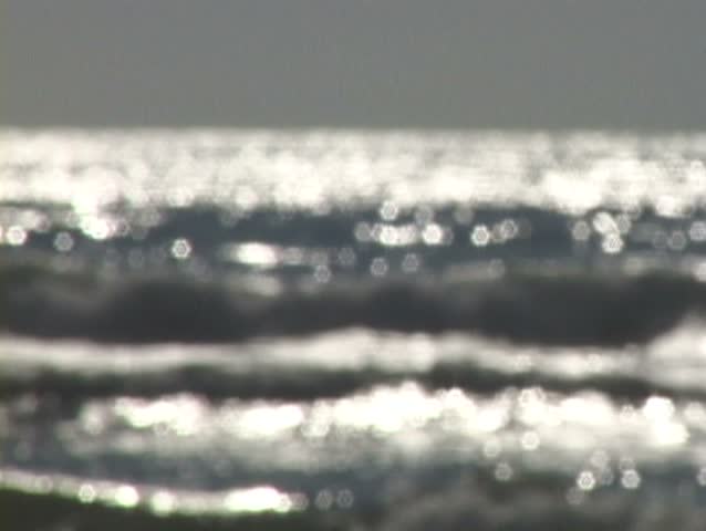 Rack focus of waves in ocean reflecting with soft focus.
