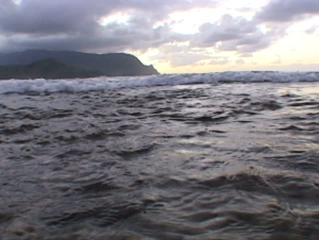 Tracking shot as wave crashes up to camera in Kauai, Hawaii.