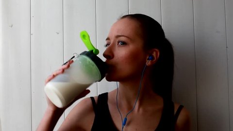 Sports girl drinks from a Shaker