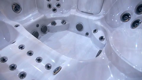 Large, new, beautiful white jacuzzi without water. Shot in motion