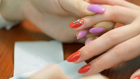 Girl decorates nail rhinestones. Nail design with rhinestones closeup. Jobs manicurist.
