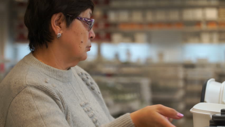 woman in a shop buying a plastic container for food