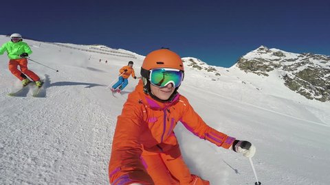 4k skiing footage, action cam selfie perspective woman and two men skiing down ski piste 
