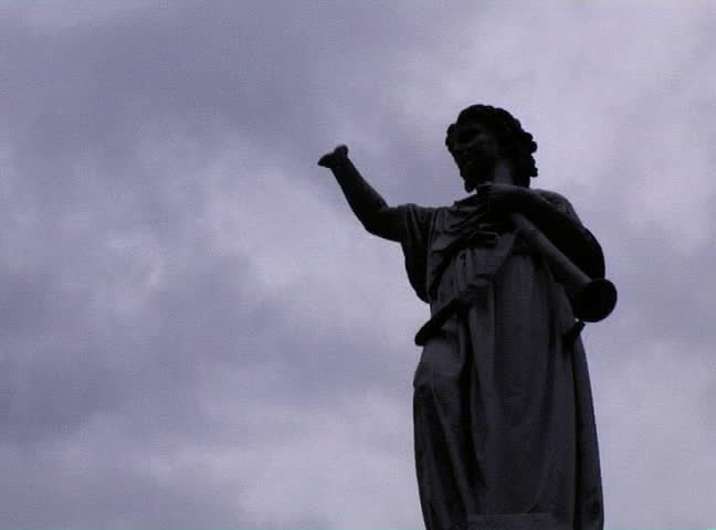 Statue sihlouette with clouds moving behind