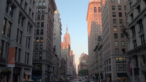 Driving past contemporary office buildings, high glassy skyscrapers, blocks of flats and apartments, distancing from iconic Empire State Building in downtown Manhattan business district in NY City Video Stok