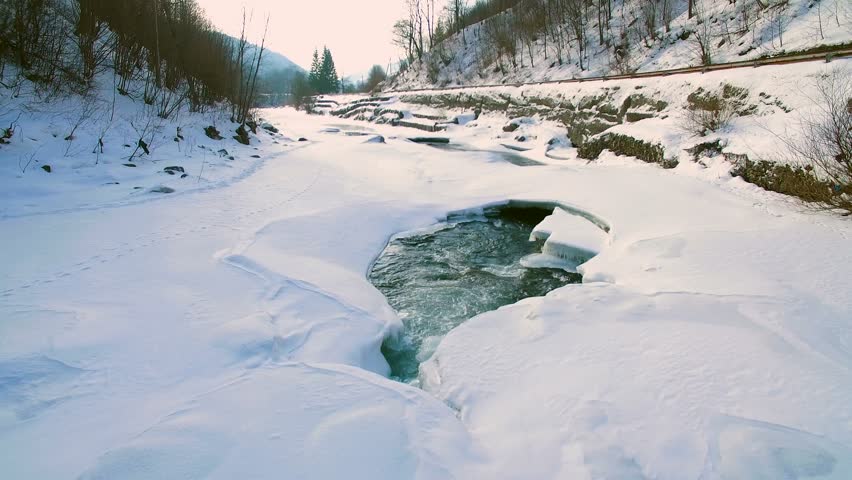 River in winter. Aerial View. Flight over the beautiful winter river and snowy forest. 
