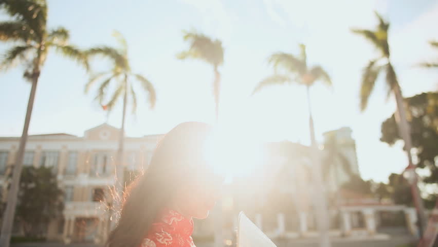 Vietnamese girl puts on a national cap Non La in the rays of the evening sunset