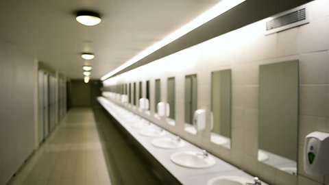 Focusing to public empty restroom with washstands and mirrors - slow focusing perspective view - concept of hygiene, cleanliness - pov of visitior
