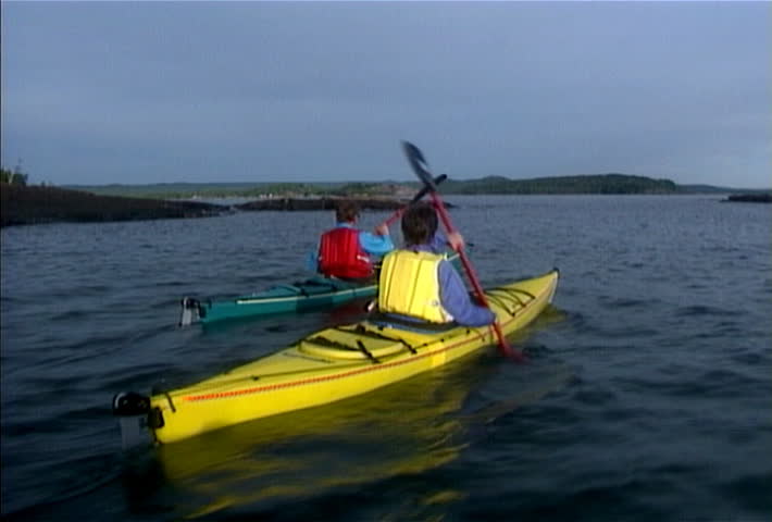 Kayakers near a rocky shoreline