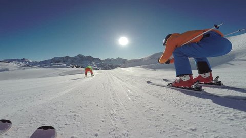 4k skiing footage, skier point of view two skiers overtaking on flat ski slope in skiing region

