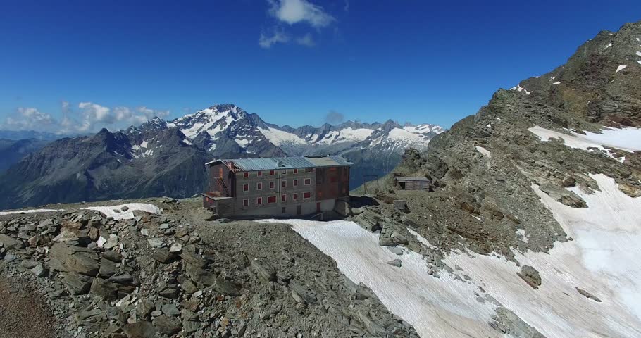 Old refuge abandoned in mountain - Aerial view on the glacier and peaks