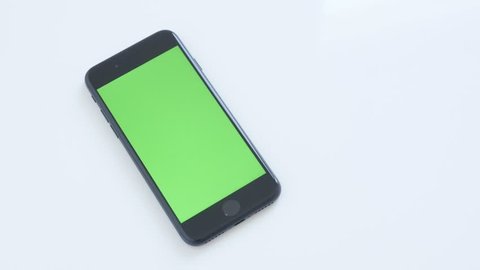 ZAJECAR, SERBIA - NOVEMBER 2016: Chroma key modern phone with green screen slow tilt on white background