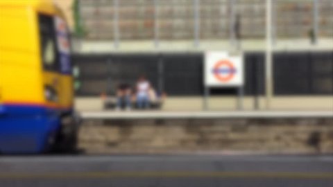 London urban train station platform passenger waiting commute overground transport arrive blurred abstract background