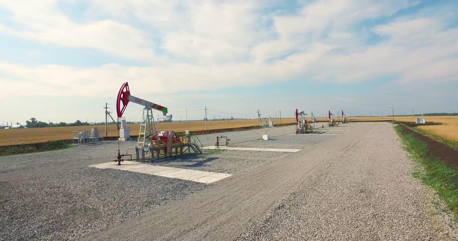 Oil pumping station it working in big agriculture field. Modern oil pump jack. Aerial photography  at summer sunny day Royalty-Free Stock Footage #23667577