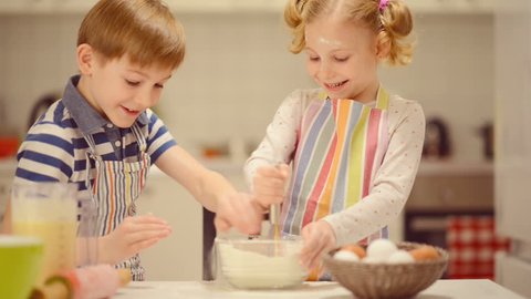 Happy  little children having fun during preparing Easter cookies at home