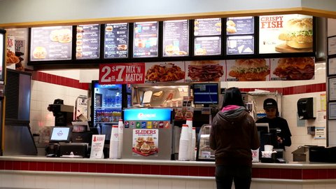 Coquitlam, BC, Canada - January 31, 2017 : Motion of people ordering food at Arby's check out counter inside mall with 4k resolution