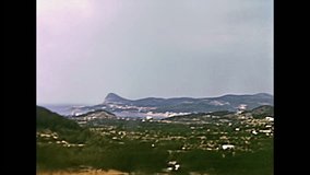 Ibiza, Spain - circa 1973: Vintage restored footage driveby in the island on old roads in the nature with few people and few buildings in the seventies.