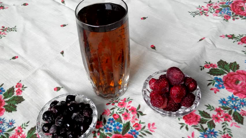 Crystal glass with a fruit drink. Berries near glass of fruit drink