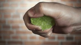 Chef's hand squeezes of green lime, close-up slow motion hd video