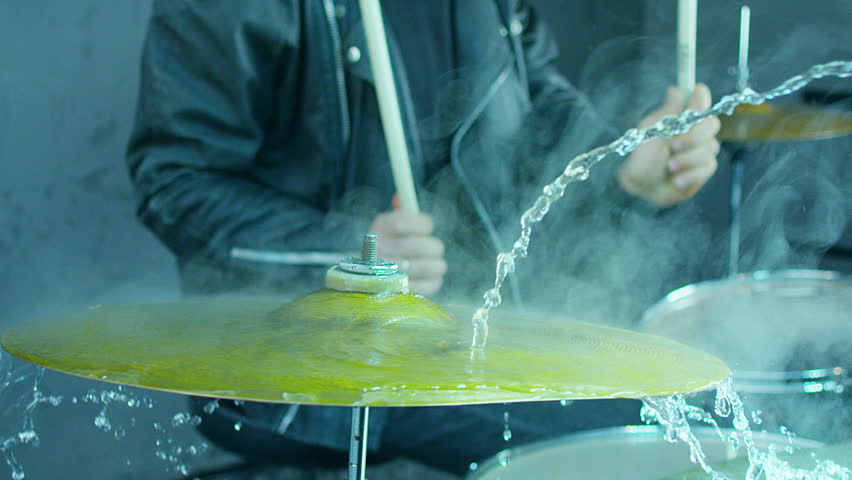 Drummer hitting on wet drum cymbal, and the water splashing from cymbal in slow motion 200 fps.  Shot on RED HELIUM Cinema Camera. Royalty-Free Stock Footage #23692039