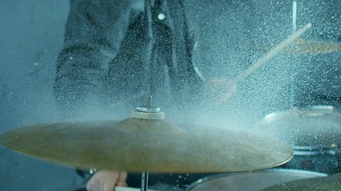 Drummer hitting on wet drum cymbal, and the water splashing from cymbal in slow motion 200 fps.  Shot on RED HELIUM Cinema Camera.