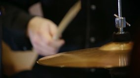 A closeup view of a hi hat cymbal played with a drumstick.