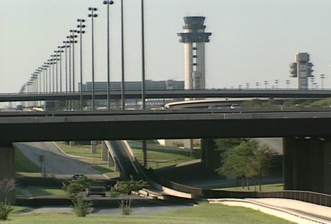 DALLAS - Circa 2002: Plane taxis over highway at the Dallas Fort Worth Airport in 2002