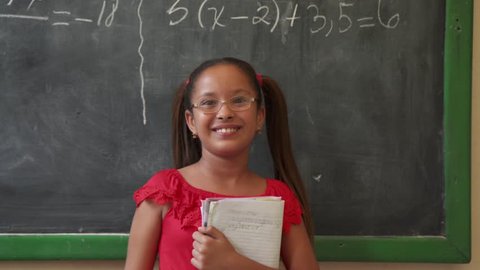 Young people and education. Group of hispanic students in class at school during lesson. Portrait of happy latina girl, hispanic student smiling at camera