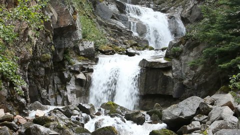 Waterfall through forest and steep rocks near Skagway, Alaska.