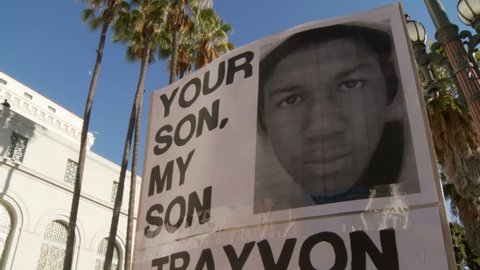 "TRAYVON IS OUR SON" Sign. Banners with the photo of slain teenager Trayvon Martin at a City Hall rally in downtown Los Angeles, California on July 16th, 2013.