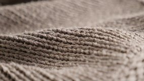 Thick wool ribbing or stockinette knitting surface close-up 4K 2160p 30fps UltraHD footage - Shallow DOF brown female sweater knitwork details slow pan 3840X2160 UHD video