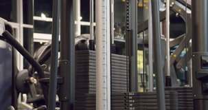 The weight stack from a cable exercise machine 4k close-up video. Gym and workout equipment for training. Working mechanism of rack machine: plates weighs twenty kg moves, lifts, rises and pulls up