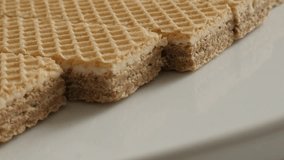 Panning on Israeli type wafer pieces on plate close-up 4K 21560p 30fps UltraHD footage -  Sweet thin biscuit waffle surface pattern slow pan 3840X2160 UHD video