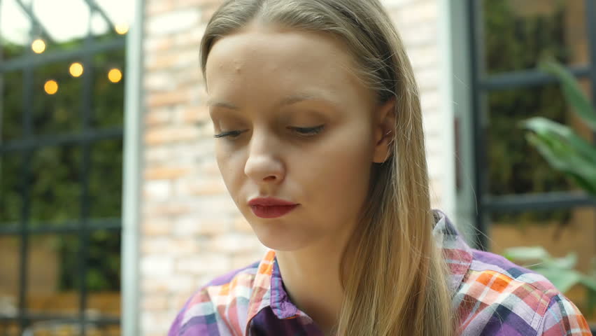 Pretty, blonde girl eating healthy lunch in the cafe and smiling to the camera
