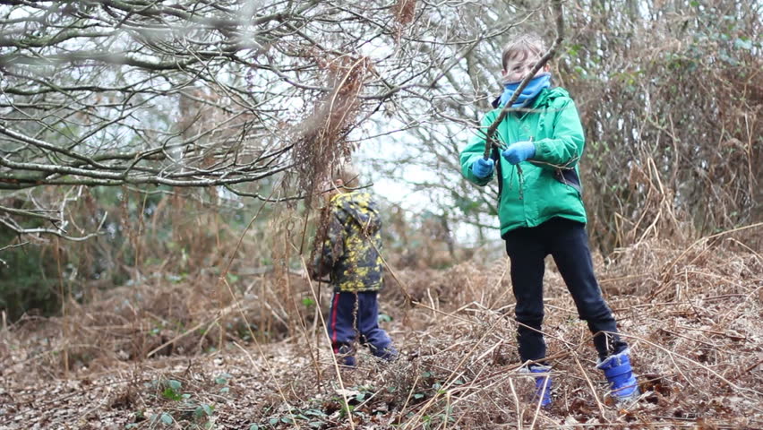 Children playing outside with sticks